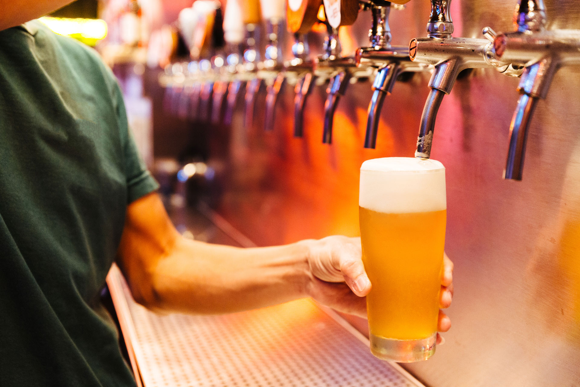 A bartender holds a freshly pulled draught of beer. 
